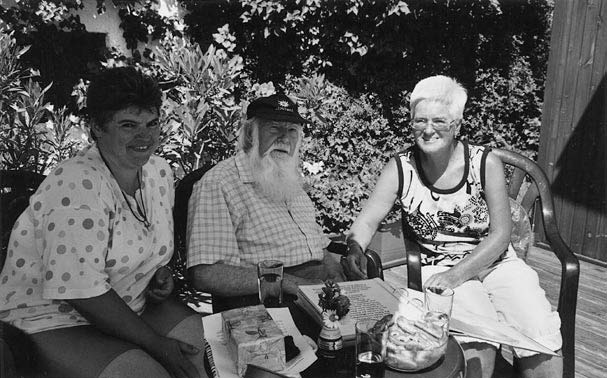 s/w-Foto: Waltraud und Christl sitzen im Garten zur Übermittlung der Geburtstagswünsche an Pater Wilfried (70 Jahre, Mitte)
