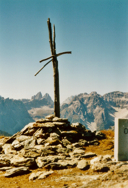 Das einfache Gipfelkreuz des Hornisch Eck (2551 m). Im Hintergrund die Zinnen.